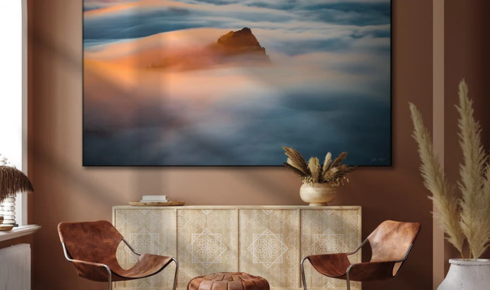 How can using a single large artwork instead of many tiny frames make a wall feel calmer